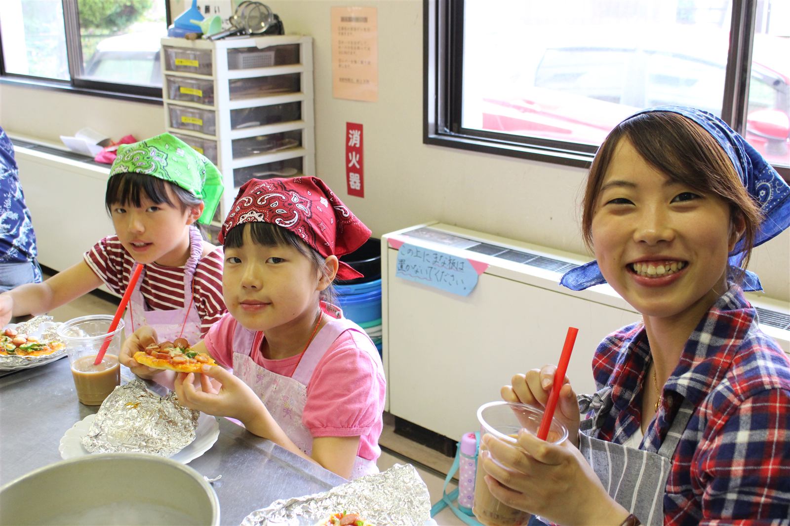 できあがった料理を笑顔で頬張る子どもたちと学生スタッフ